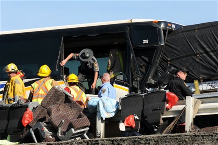 A Pennsylvania State Police trooper climbs out of the emergency exit after looking over the damage caused to a tour bus carrying a group of Asian tourists that plowed into the back of a tractor trailer along the East bound lane of the Pennsylvania Turnpike near milepost 95, about five miles east of the Donegal interchange, Monday, June 27, 2011. The driver of the bus was killed and nearly two dozen passengers were injured, officials said. (AP Photo/Greensburg Tribune Review, Sean Stipp)
